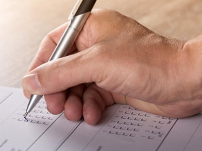 Hand with Pen on Voting Ballot