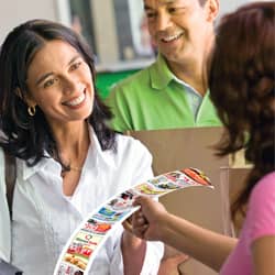 Smiling woman takes a custom printed receipt from cashier