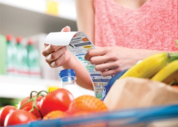 Shopper Holds Custom Printed Receipt in Front of Fruit at Grocery or Convenience Store