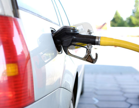 White Car with Gas Pump Nozzle Inside Gas Tank