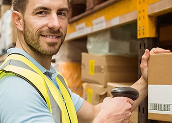 Man Scans Barcode Label in Warehouse