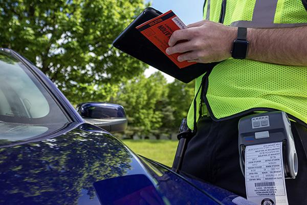 Officer prints parking ticket on mobile printer