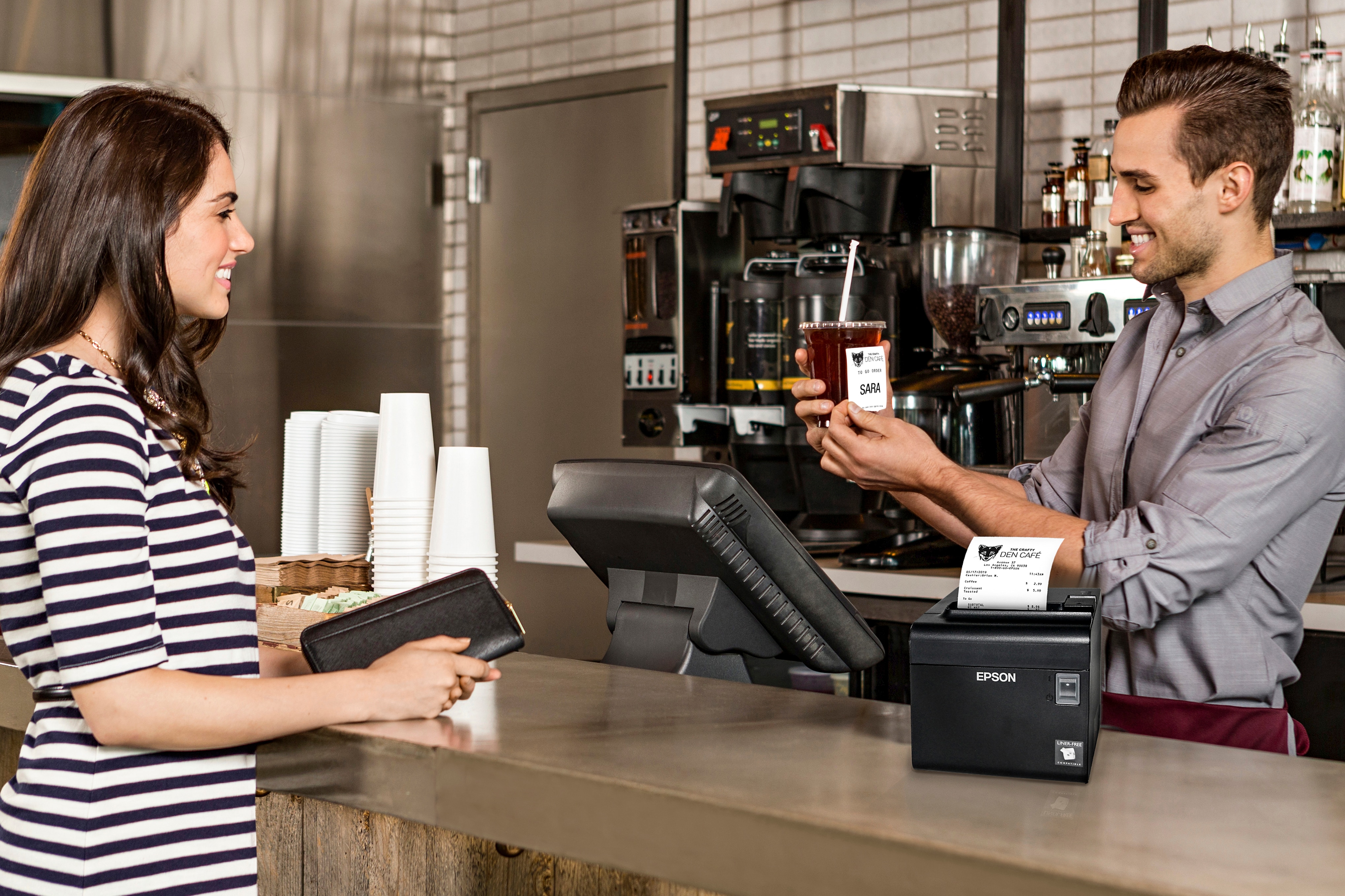 Restaurant employee places POS Sticky label on drink for customer