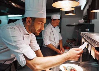 Restaurant Chef Looks at Food Order Ticket