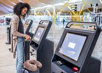 Woman at Airport Kiosk Printing Boarding Pass