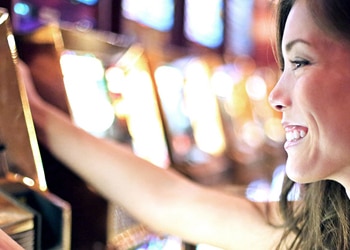 Smiling Woman Plays Slot Machine