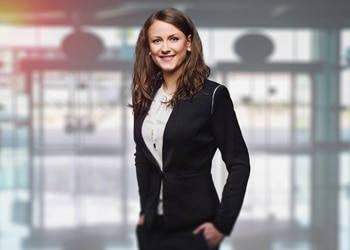 Business Woman Standing in Front of Doors at a Bank